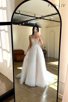 a woman in a white dress taking a selfie with her cell phone while standing in front of a mirror