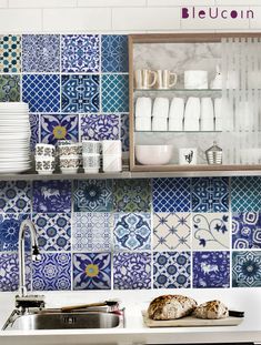 a kitchen with blue and white tiles on the wall