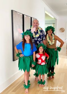 two adults and two children dressed up as hula dancers