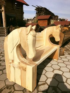 a wooden horse bench sitting on top of a cobblestone street next to a building