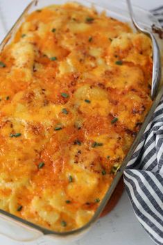 a casserole dish with cheese and parsley on the side, ready to be eaten