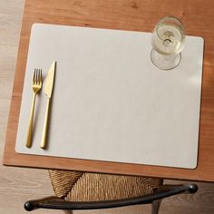 a placemat with a fork and knife on it next to a glass of water