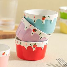 four bowls are stacked on top of each other with strawberries and cherries painted on them