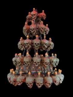 a chandelier with skulls hanging from it's sides and candles in the middle