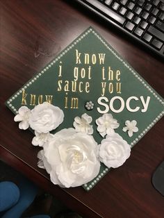 a green graduation cap with white flowers on it and the words i know i got the sauce you know i'm soccy