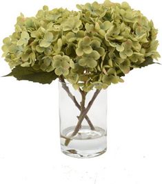 a vase filled with green flowers on top of a white table