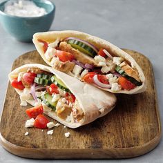 two pita sandwiches on a wooden cutting board