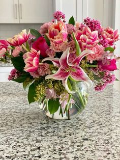 a vase filled with pink flowers on top of a counter