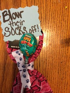 a candy bar wrapped in red and white fabric with a sign reading blow their socks off