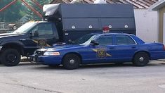 a police car parked next to a garbage truck