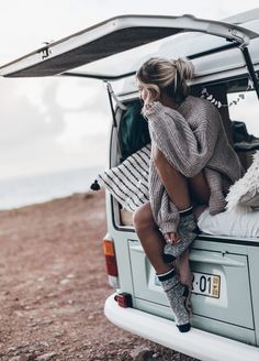 a woman sitting in the back of a van