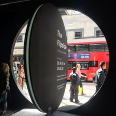 people standing in front of a red bus