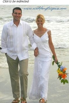 a man and woman walking on the beach holding hands with flowers in each others hand