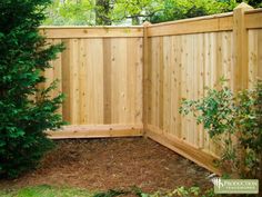 a wooden fence surrounded by trees and bushes