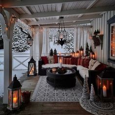 a covered porch with christmas decorations and lit candles