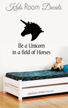 a child's room with a bed and wall decal that says, be a unicorn in a field of horses