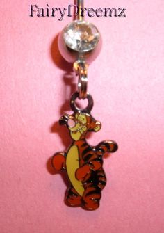 a winnie the pooh belly button charm on a pink background