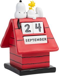 a snoopy dog sitting on top of a red house with the number twenty four