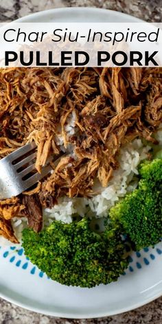 a white plate topped with pulled pork and rice next to broccoli on a table