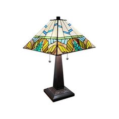 a table lamp with a stained glass shade on it's base and an ornate design