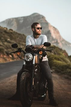 a man with a beard sitting on a motorcycle