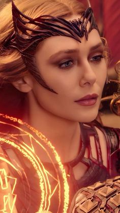 a close up of a person wearing makeup and holding a light saber in her hand