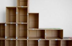 several cardboard boxes stacked on top of each other in front of a white wall and floor