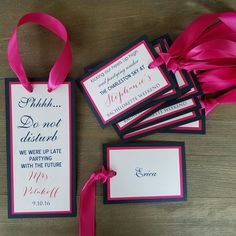 pink and black wedding stationery with matching ribbon on wooden table top, including place cards