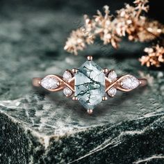 a ring with an aqua blue topazte surrounded by white diamonds on a marble slab