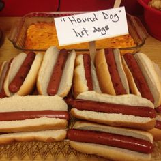 there are many hotdogs on the table with a sign that says hound dog hot dogs