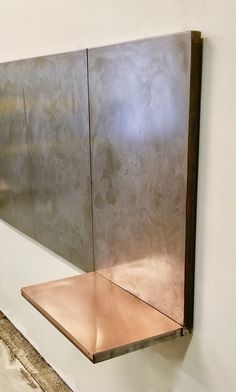 a metal shelf mounted to the side of a wall