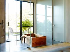 a bath tub sitting inside of a bathroom next to a walk - in shower and sliding glass doors