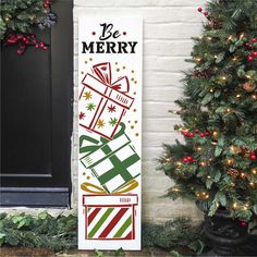 a christmas door hanger with presents on it and the words be merry in front of a decorated tree