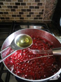 a pot filled with red liquid sitting on top of a stove