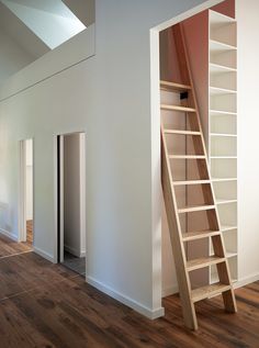 a ladder leaning against the wall next to a book shelf in a room with white walls