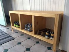 a wooden shelf filled with shoes on top of a tiled floor