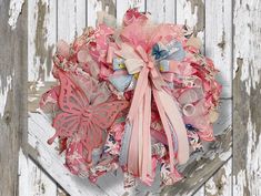 a bunch of pink and blue flowers sitting on top of a white wooden wall next to a fence