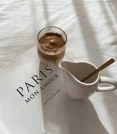 a cup of coffee sitting on top of a paper with the word paris in it