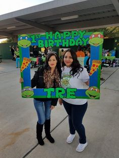 two women standing in front of a birthday sign