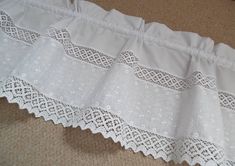 a white lace curtain is laying on the floor