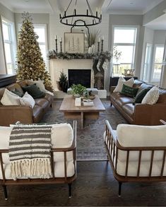 a living room with couches, chairs and a christmas tree in the centerpiece