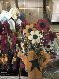 a vase filled with lots of flowers on top of a wooden table next to boxes