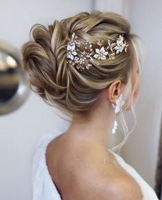 a woman in a white dress is looking at herself in the mirror wearing a hair comb