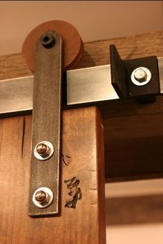 two metal latches are attached to the side of a wooden door with screws