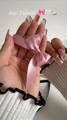 a person holding a pink ribbon in their hand