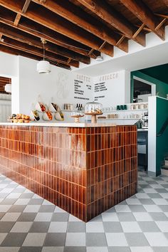 a kitchen with checkered flooring and white walls, along with an island counter