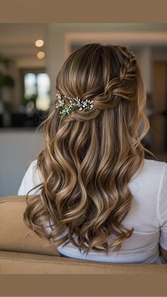 the back of a woman's head with long wavy hair and flowers in her hair