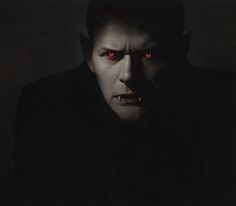 a man with red eyes in the dark