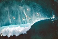 an aerial view of surfers riding waves in the ocean