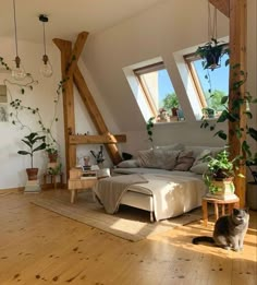 a cat sitting on the floor next to a couch in a room with wooden floors